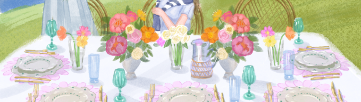 Two women at a table set for a meal by a lakeside with flowers and glasses.