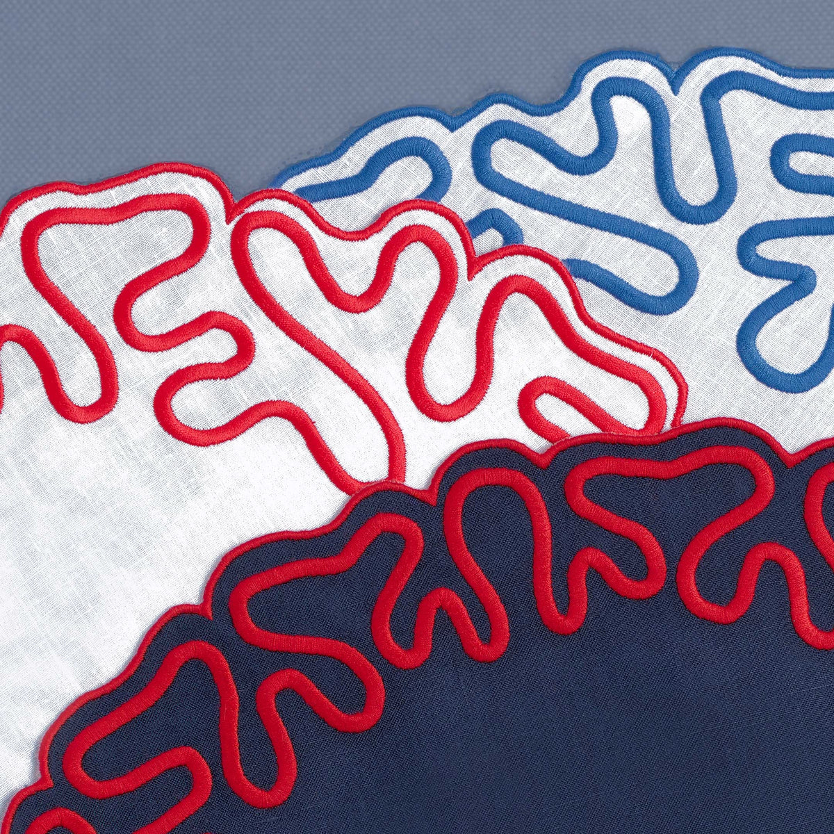 Close-up of abstract embroidered corals on white linen