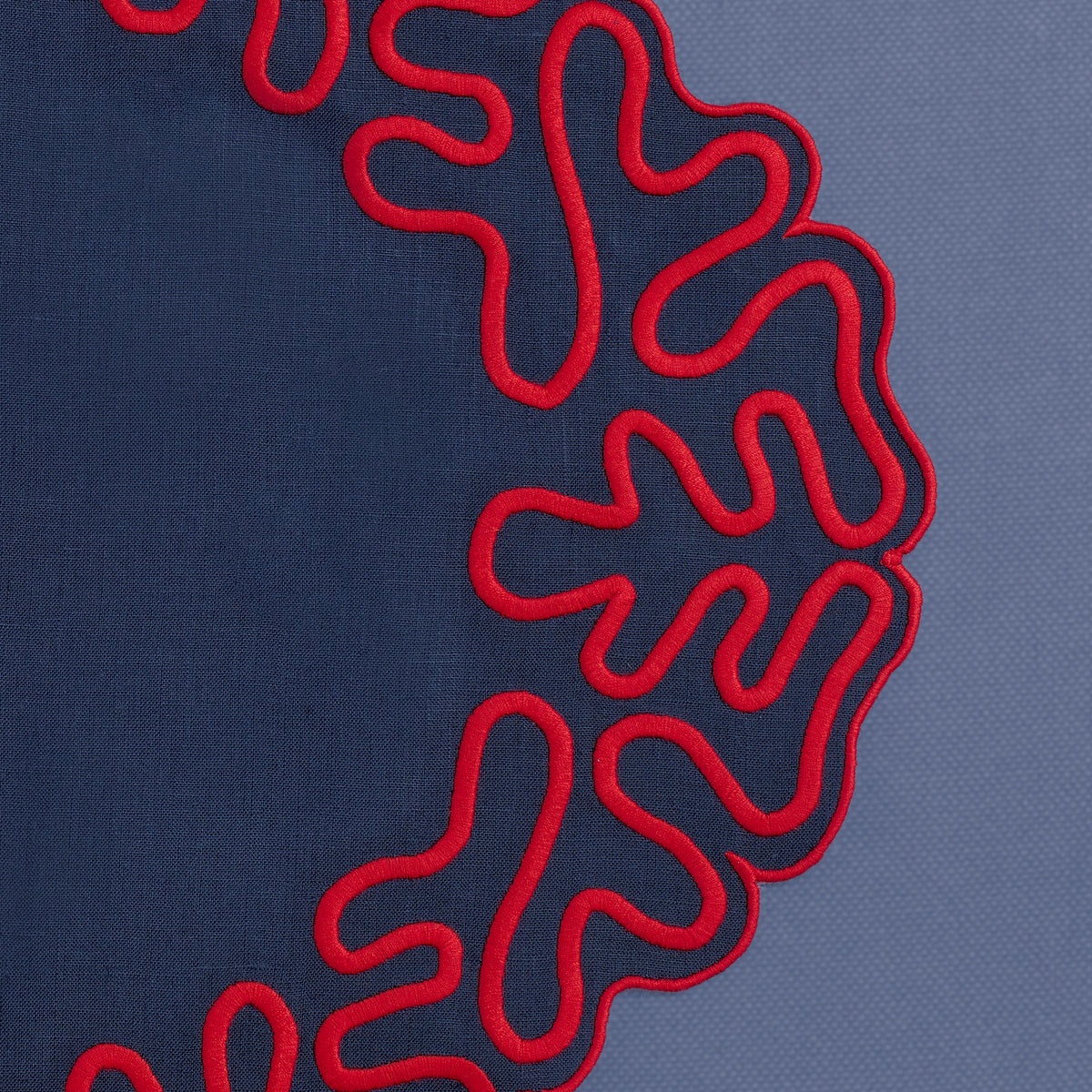 Close-up of abstract embroidered corals on white linen