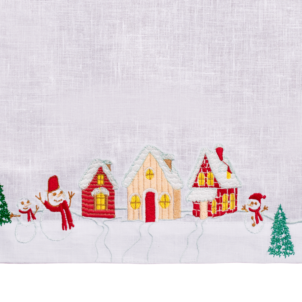 Close-up of embroidered winter chalet scene on white linen
