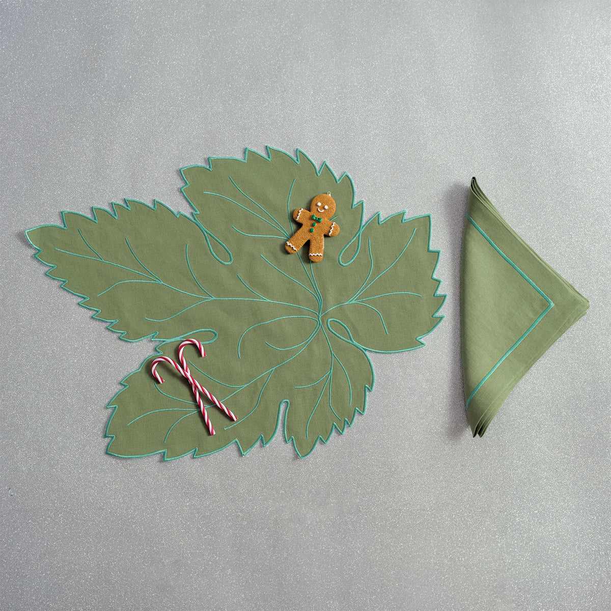 Close-up of embroidered vine leaves on white linen