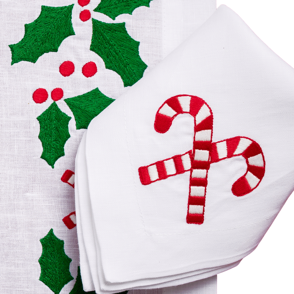 Close-up of embroidered holly and candy canes on white linen
