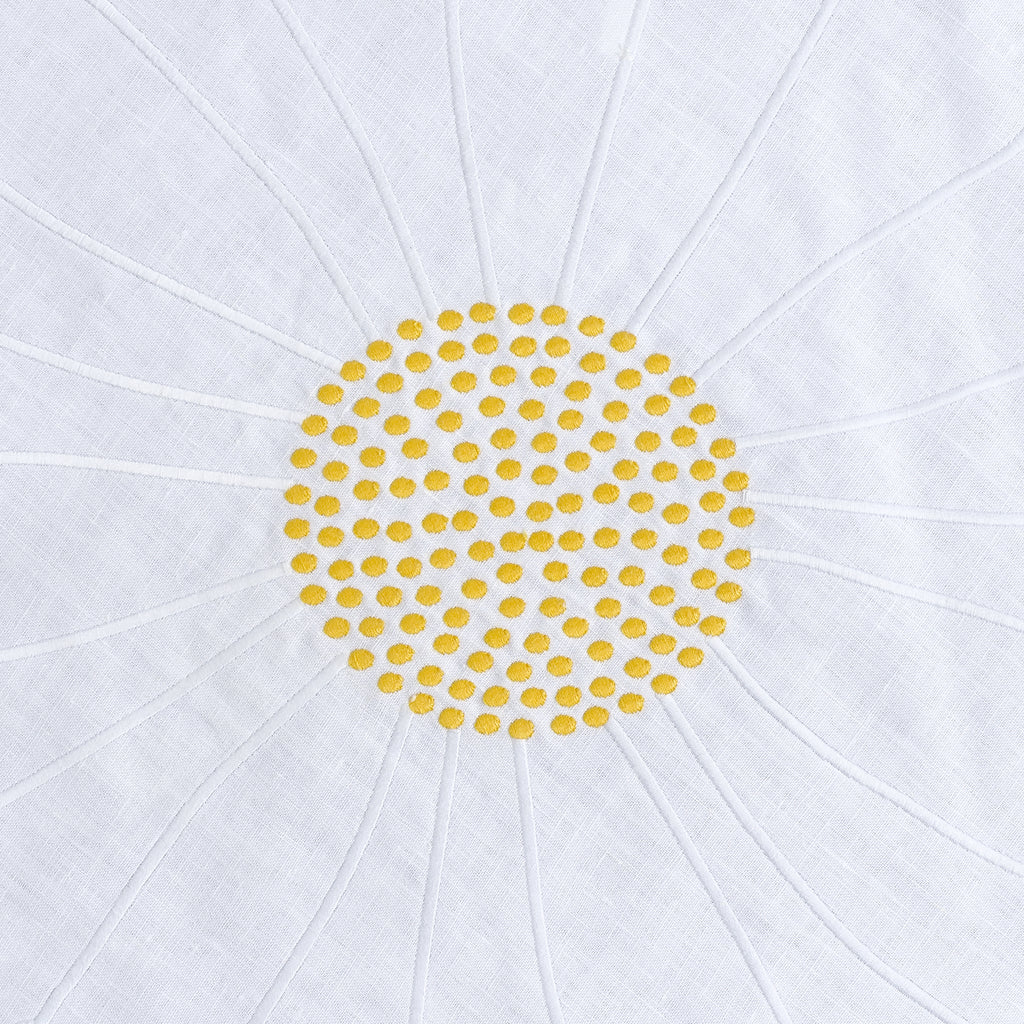 Close-up of embroidered daisies on round white linen
