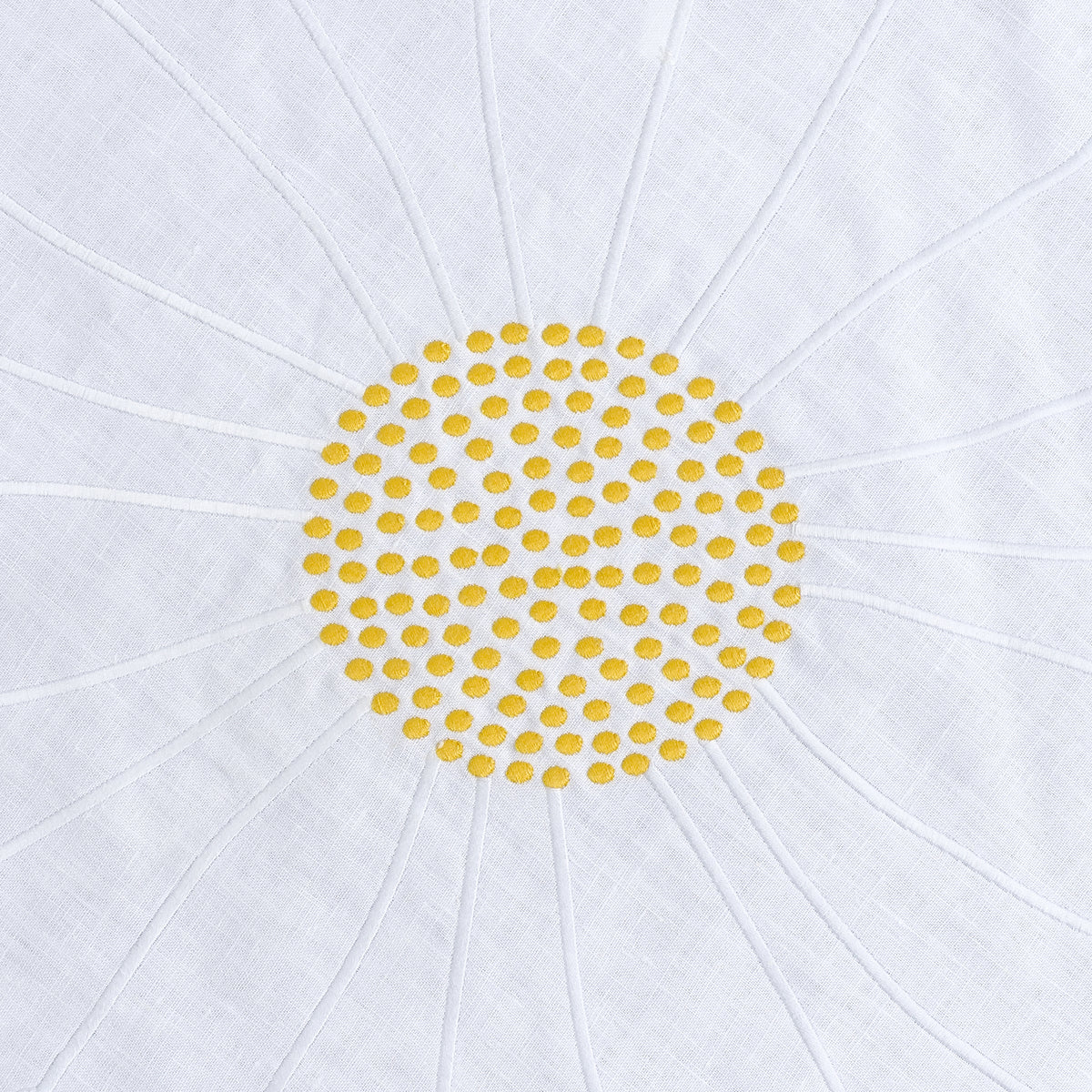 Close-up of embroidered daisies on round white linen