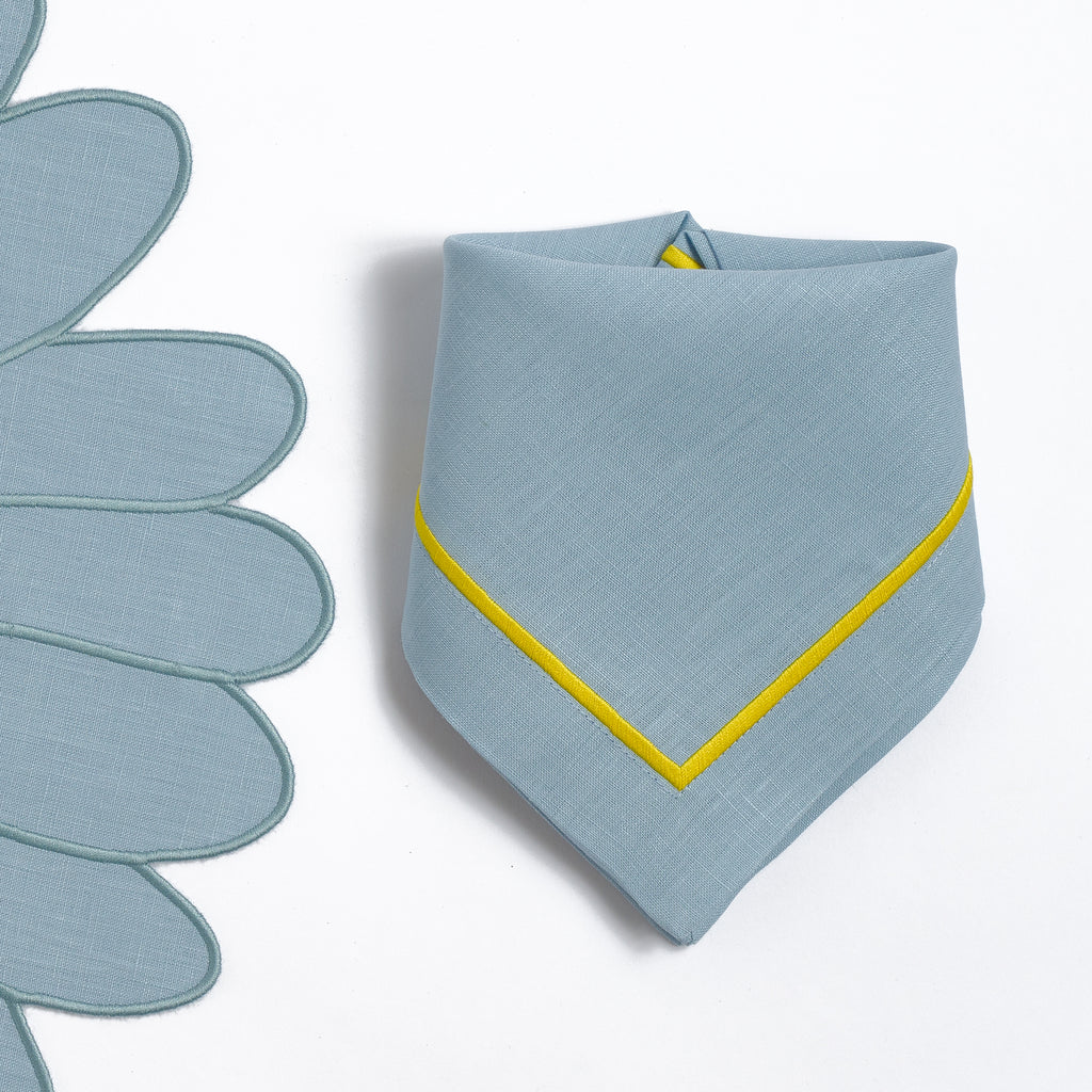 Close-up of embroidered daisies on white linen
