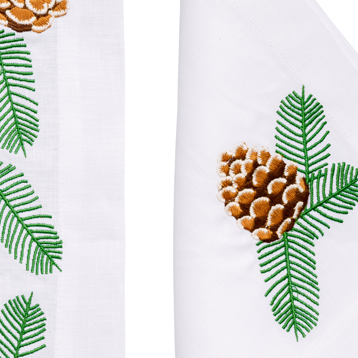 Close-up of embroidered pine branches and pinecones on white linen