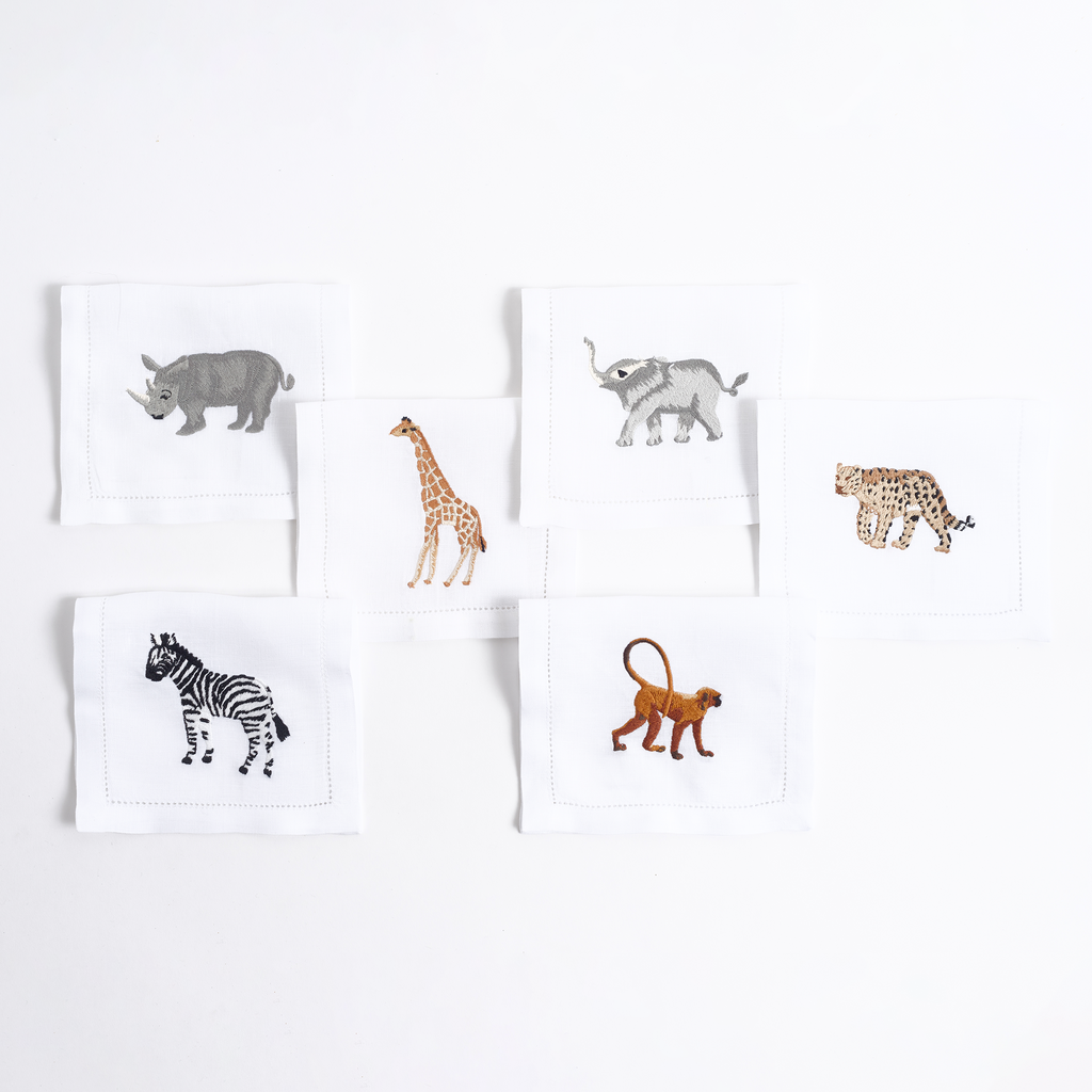 Close-up of embroidered savanna animal on white linen cocktail napkin