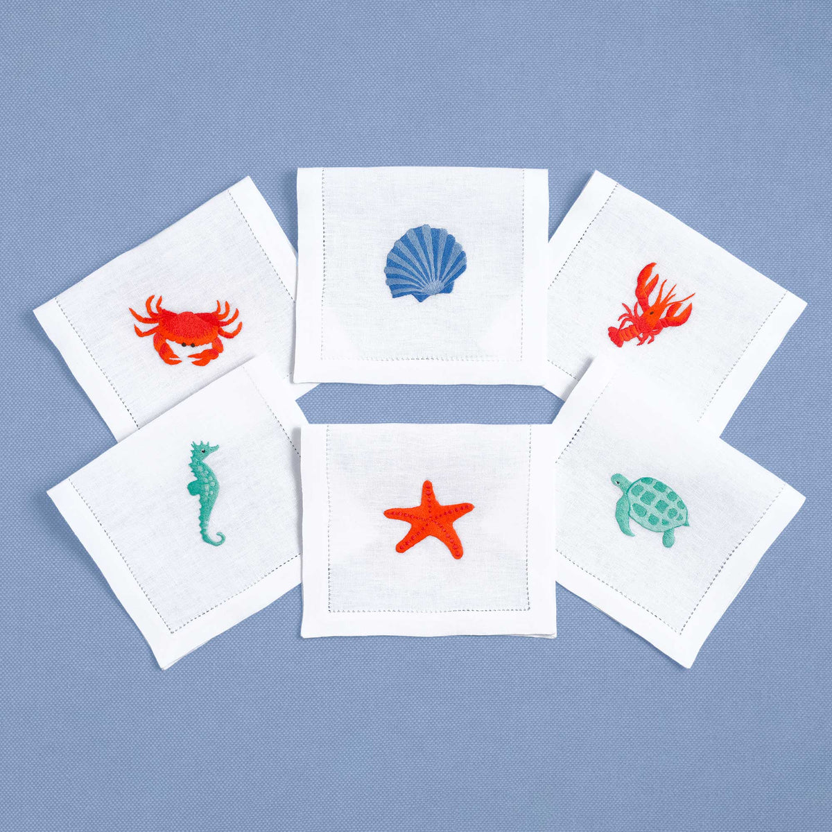 Shellfish embroidered seafood motif on white linen cocktail napkin