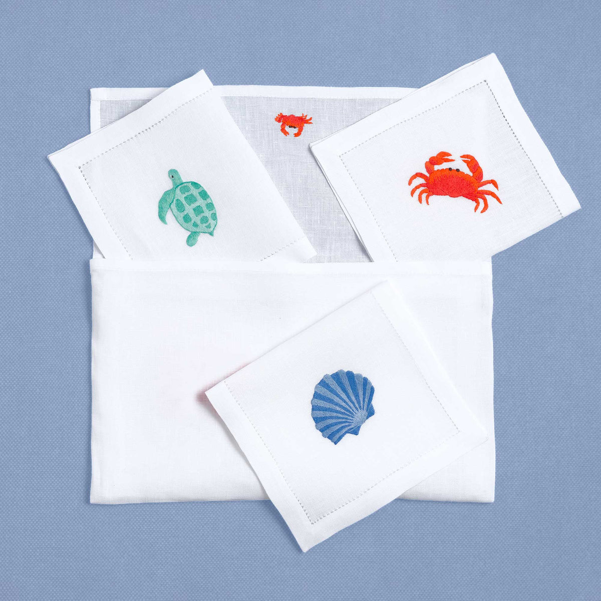 Shellfish embroidered seafood detail on white linen cocktail napkin