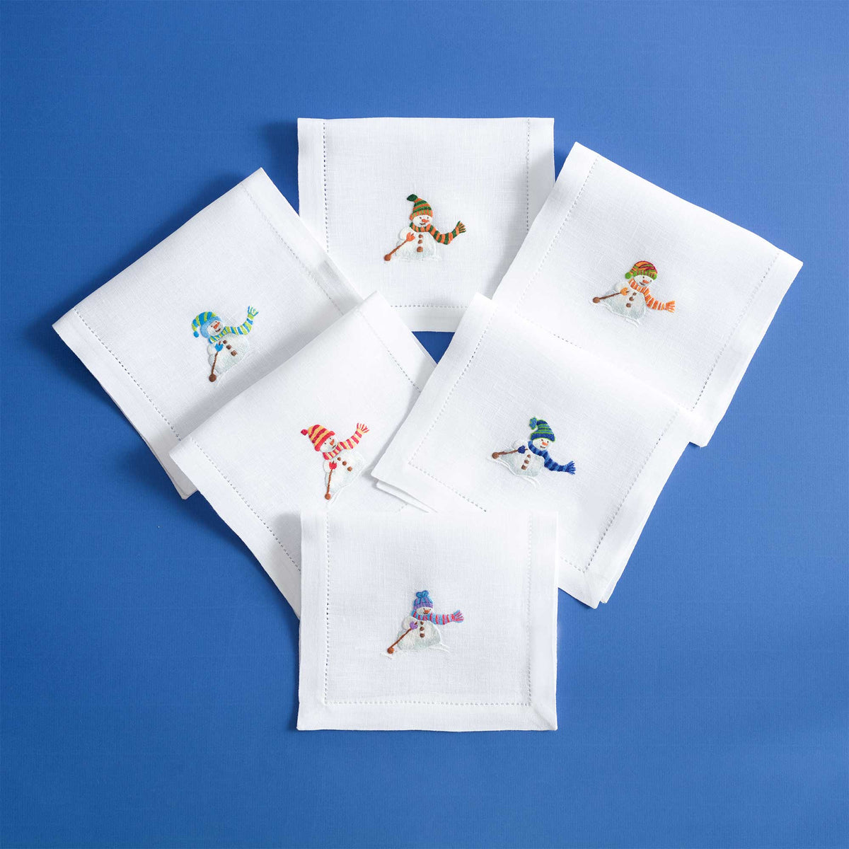 Close-up of embroidered snowman on white linen cocktail napkin