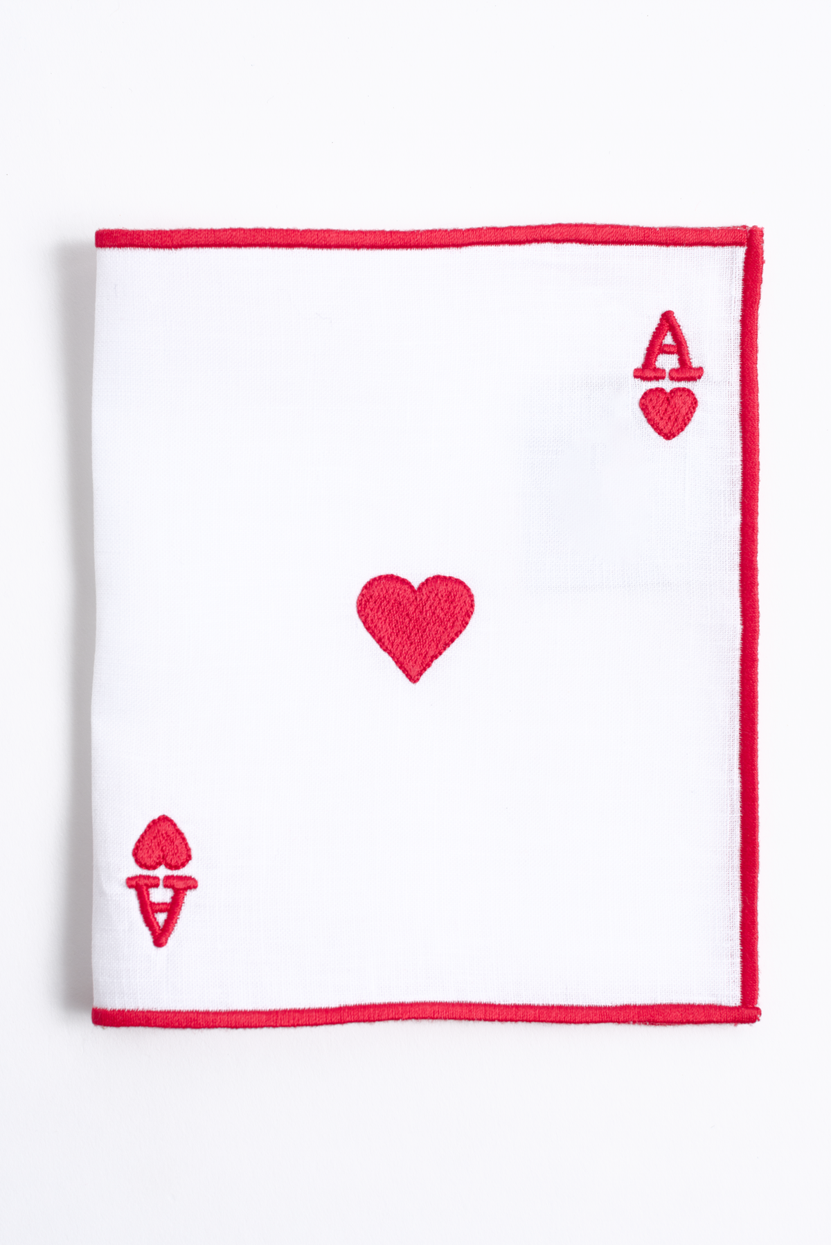 Embroidered ace motif on white linen cocktail napkin