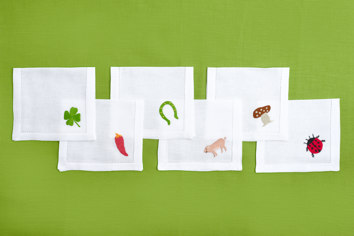 Close-up of embroidered lucky charms on white linen cocktail napkin